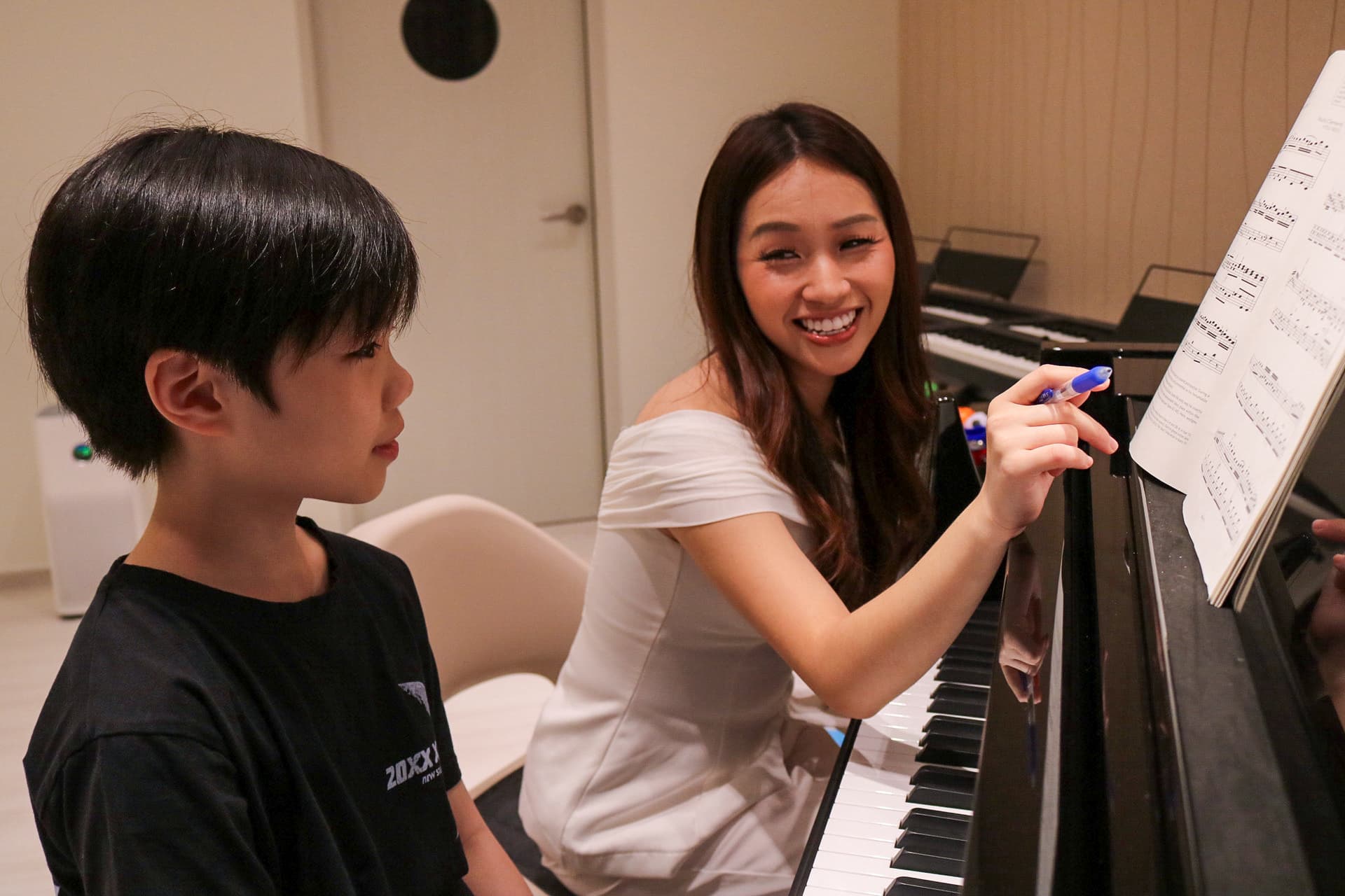 A Polaris teacher guiding a young student at the grand piano