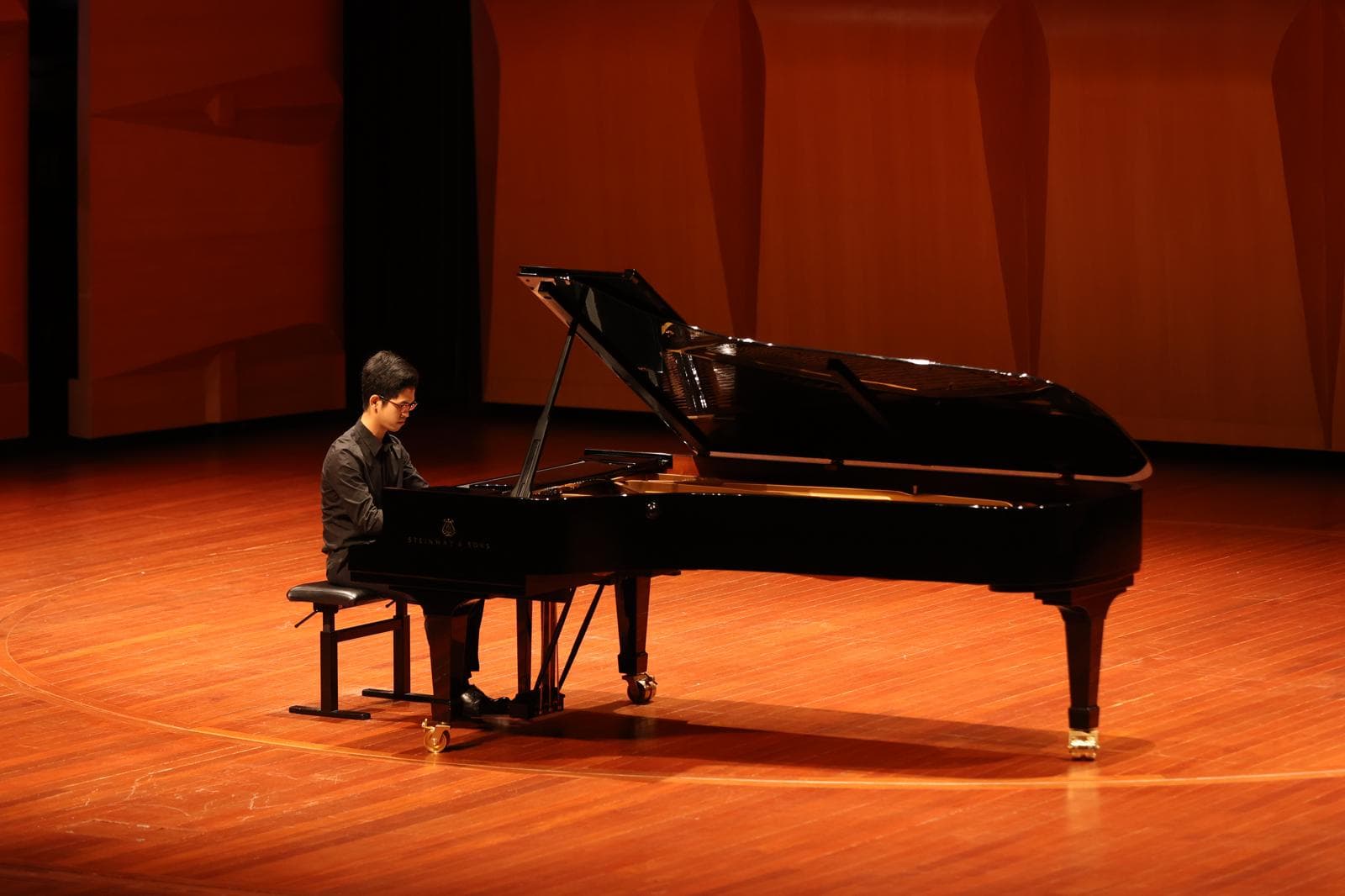 Tan Yu Mu performing on stage in a concert hall
