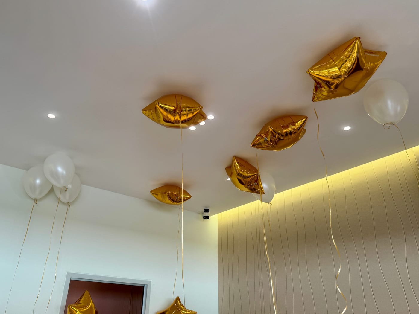 Gold star balloons floating against the studio ceiling